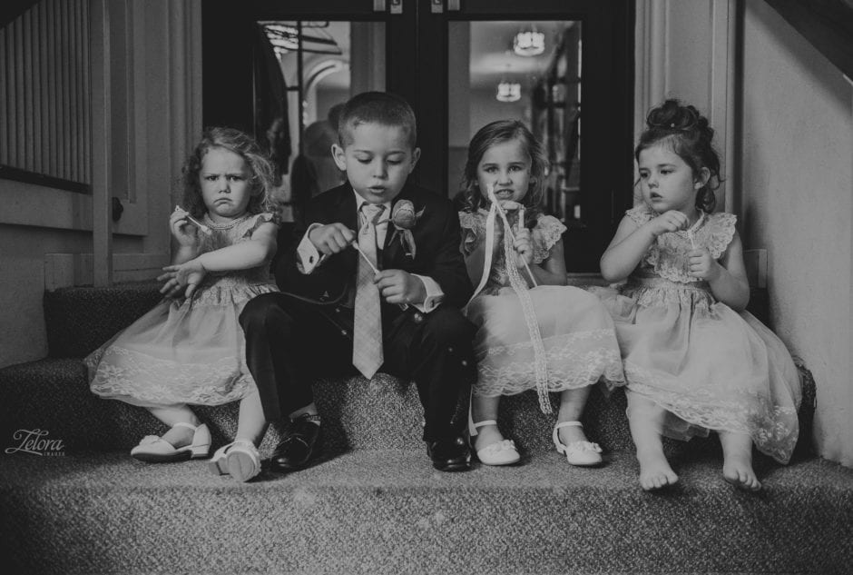 Two happy flower girls blowing bubbles and one sad one from spilling her bubbles