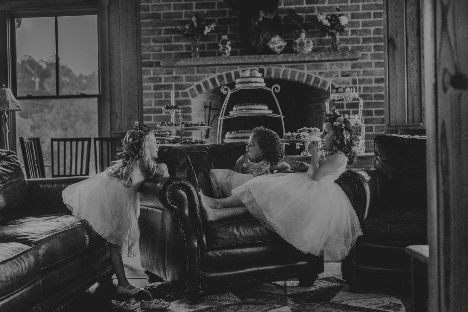 Three little flower girls lounging and chatting in a room